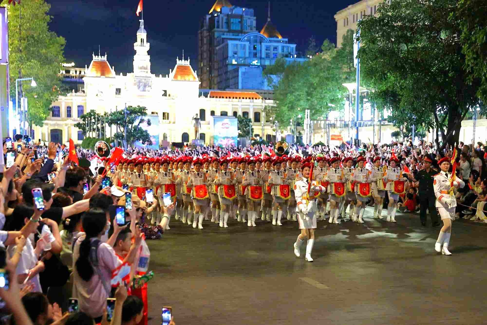 Sau khi hoàn thành bài luyện diễu binh qua lễ đài, quân đội các nước rẽ ra 4 hướng đi nhiều km qua các tuyến phố, giữa tiếng reo hò, cổ vũ của người dân. Trong ảnh là đoàn đi qua phố đi bộ Nguyễn Huệ.